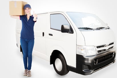 Happy delivery woman holding cardboard box against white delivery van-1