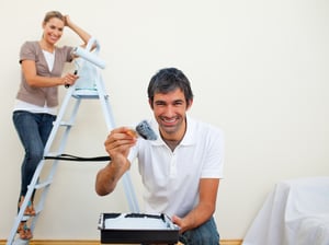 Smiling couple painting a wall of their new house