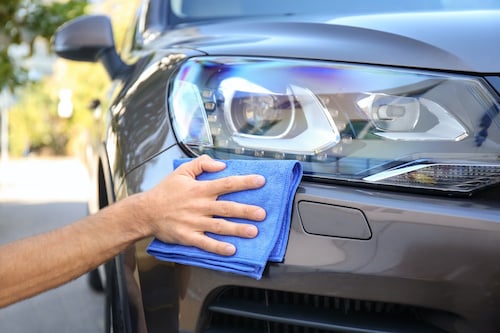 hand buffing headlight on car