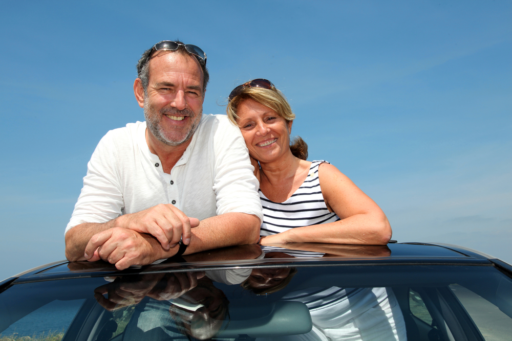 couple standing out of sun roof